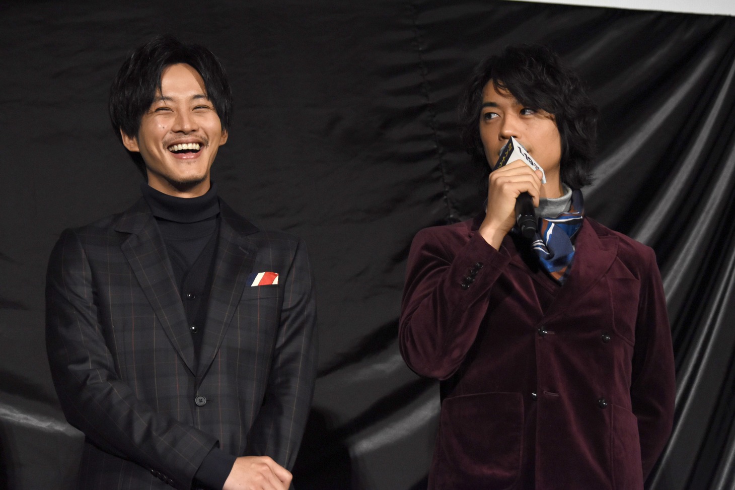 松坂桃李（左）と、パディントンにぬるぬるプロレスのバイトを薦める斎藤工（右）。