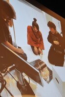 映画秘宝のグラビアメイキングカット。劇団☆新感線のパンフレットでポーズを研究する様子。