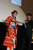 グラビア撮影で使用した“折れずの刀”を手に「あれ？」とリアクションするのん（左）。