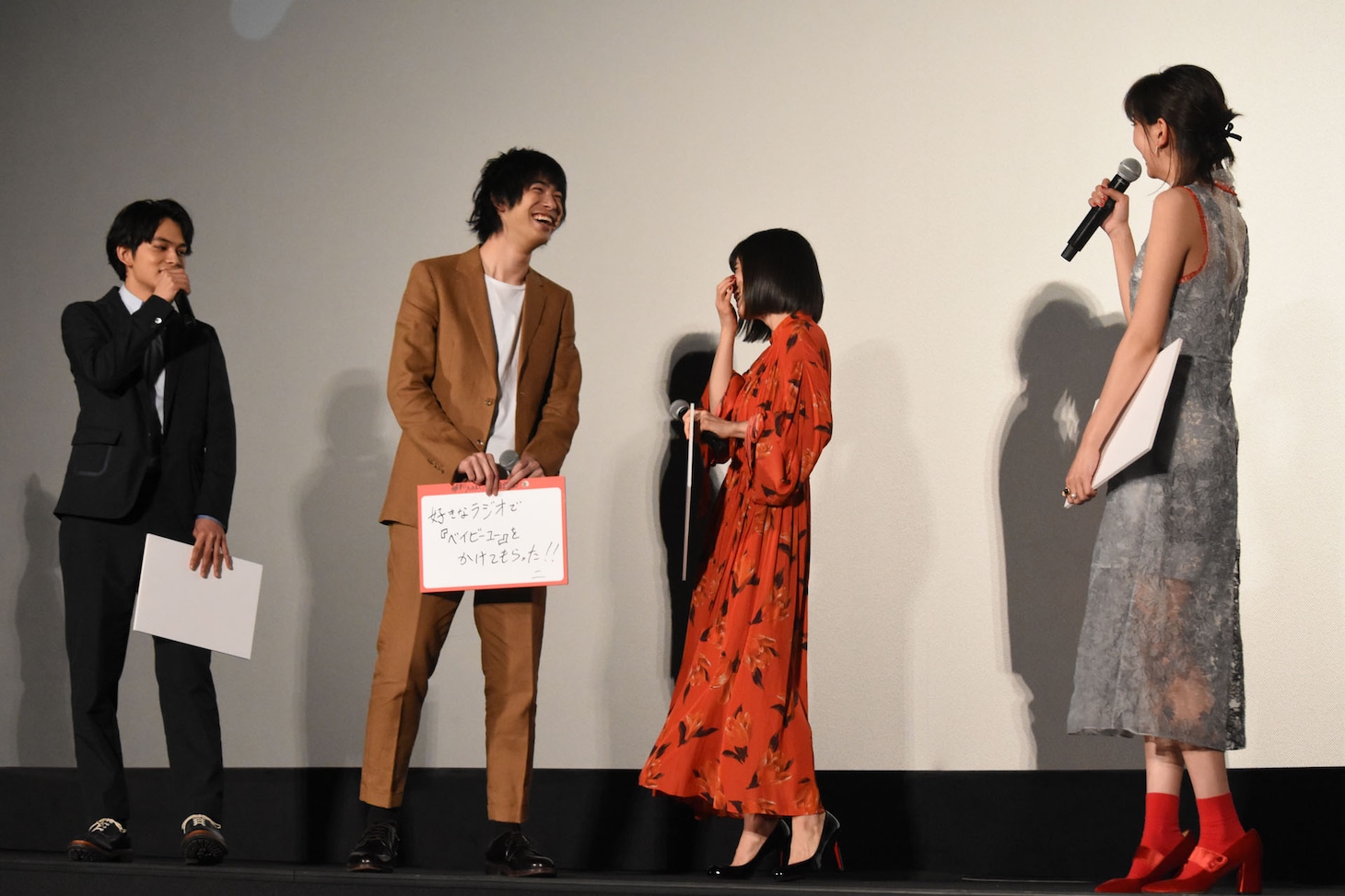 石橋杏奈（右端）のフリップをこっそり見て爆笑する松岡茉優（中央右）。