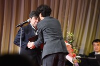 ユースケ・サンタマリア（右）から花束を受け取る岸善幸（左）。