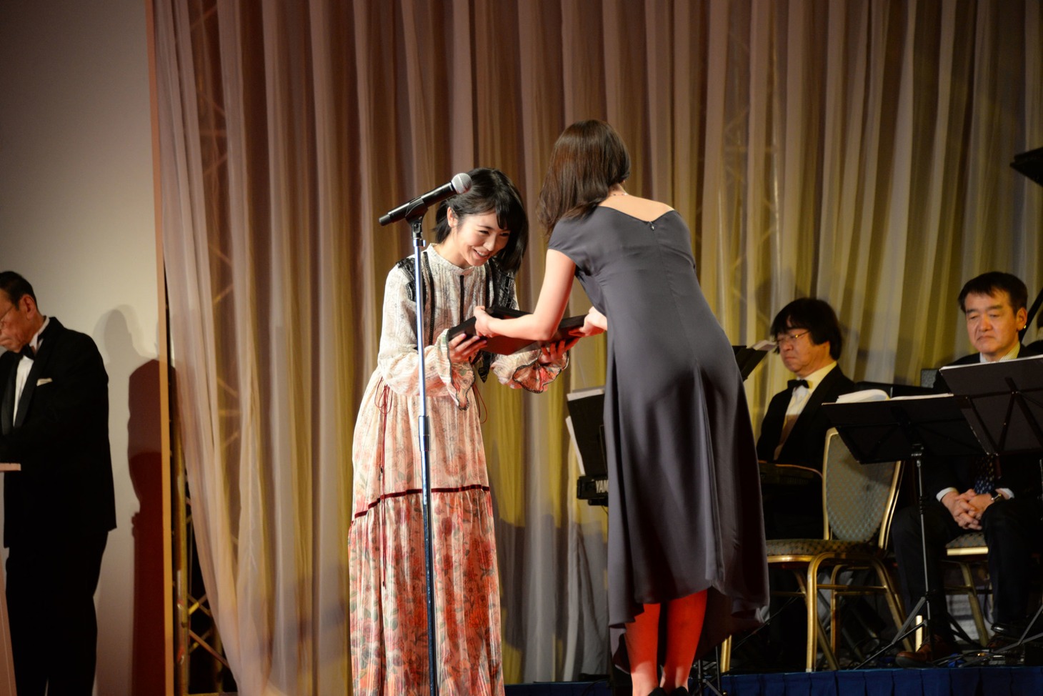 浜辺美波（奥）が有村架純（手前）から表彰盾を受け取る様子。