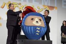 パディントンだるまに帽子をかぶせるヒュー・ボネヴィル（左）と、ヒュー・グラント（右）。