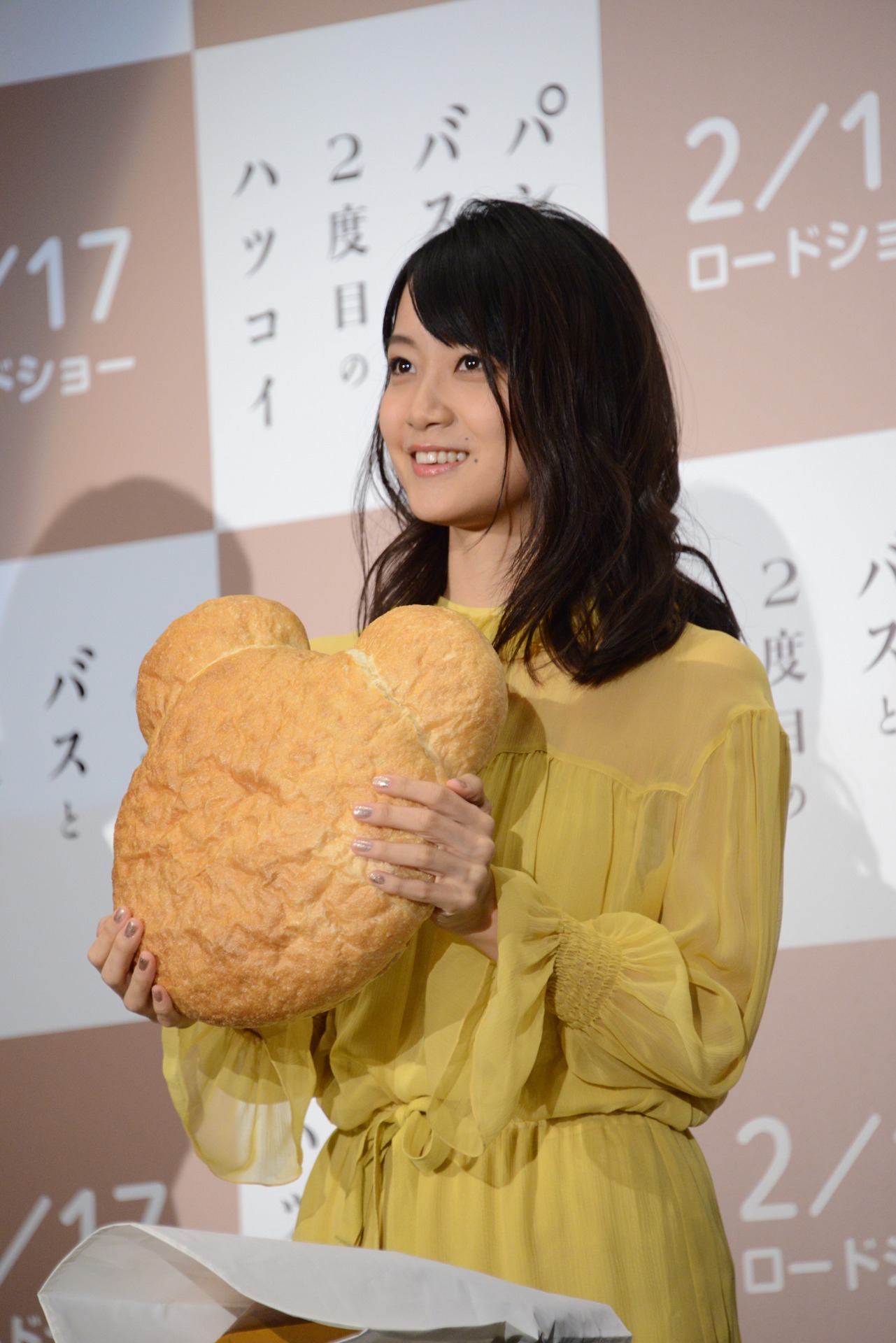 特大バージョンの“くまさんパン”を持つ深川麻衣。