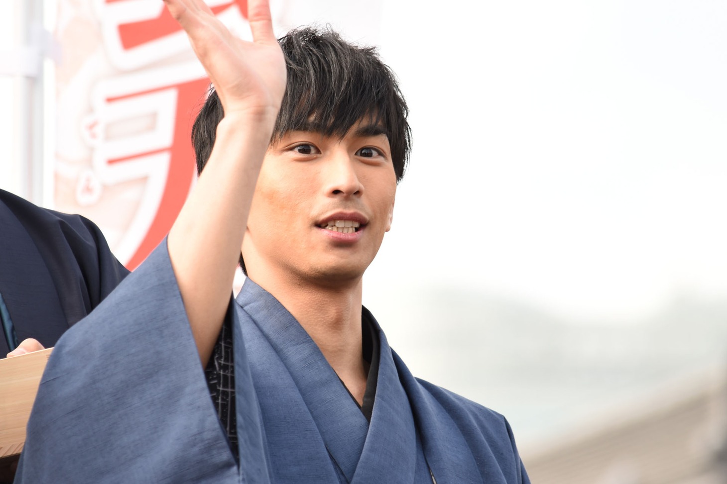 ファンへおひねりの飴を配る市川知宏。