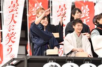 ファンへおひねりの飴を配るキャストたち。