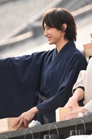 ファンへおひねりの飴を配る小関裕太。