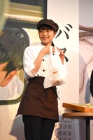 くまさんパンが入った袋を持つ深川麻衣。