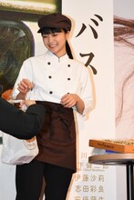 スタッフからくまさんパンを受け取る深川麻衣。