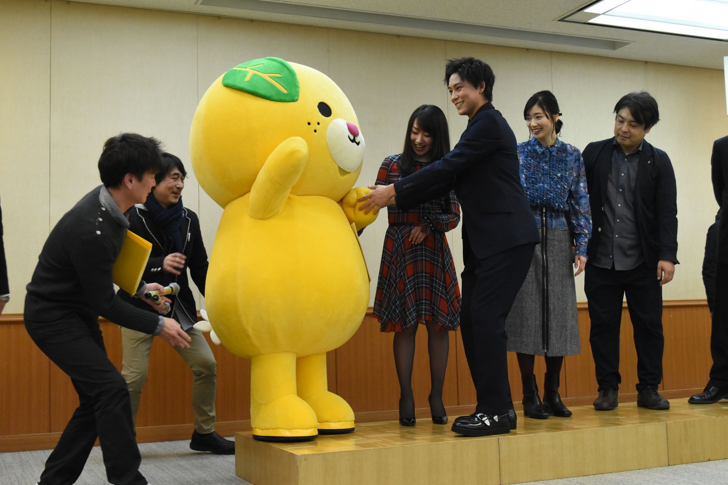みきゃんがステージに上がるのを手伝う佐野岳（前列右）。