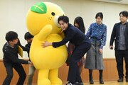 みきゃんがステージに上がるのを手伝う佐野岳（前列右）。