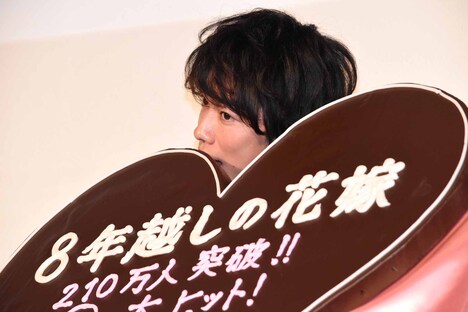 巨大なチョコレートをかじろうとする佐藤健。