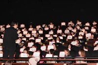 感想が書かれたボードをまじまじと見る吉田大八監督（左）。