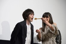 林遣都（左）に肉じゃがを食べさせる池田エライザ（右）。