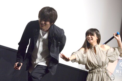 池田エライザ(奥)から“ケツバット”を受け、痛がる林遣都(手前)。