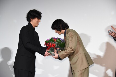 染谷将太に花束を手渡す野田洋次郎（Vo, G, Piano / RADWIMPS）。