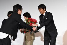 阿部寛に花束を手渡す桑原彰（G / RADWIMPS）。