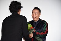 チェン・カイコー監督に花束を手渡す野田洋次郎（Vo, G, Piano / RADWIMPS）。