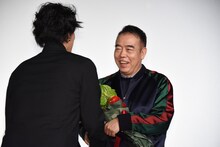 チェン・カイコー監督に花束を手渡す野田洋次郎（Vo, G, Piano / RADWIMPS）。