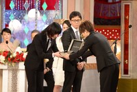 プレゼンターの岩田剛典（右）から賞を受け取る菅田将暉（左）。