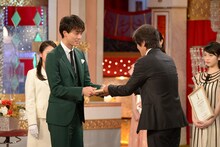 プレゼンターの佐藤浩市（右）から賞を受け取る竹内涼真（左）。