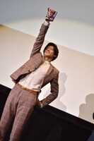 小説版「仮面ライダーエグゼイド」のサンプル本を掲げる岩永徹也。