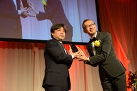 賞を受け取る岸善幸（左）。
