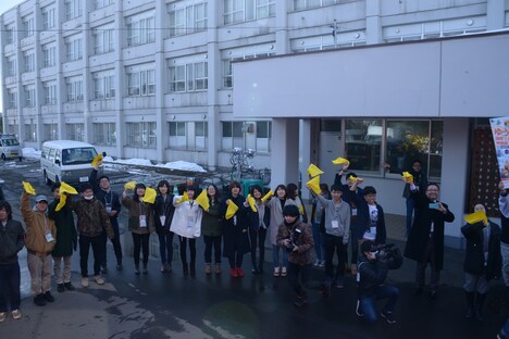 黄色いハンカチを振りながらゲストを見送る地元住民。