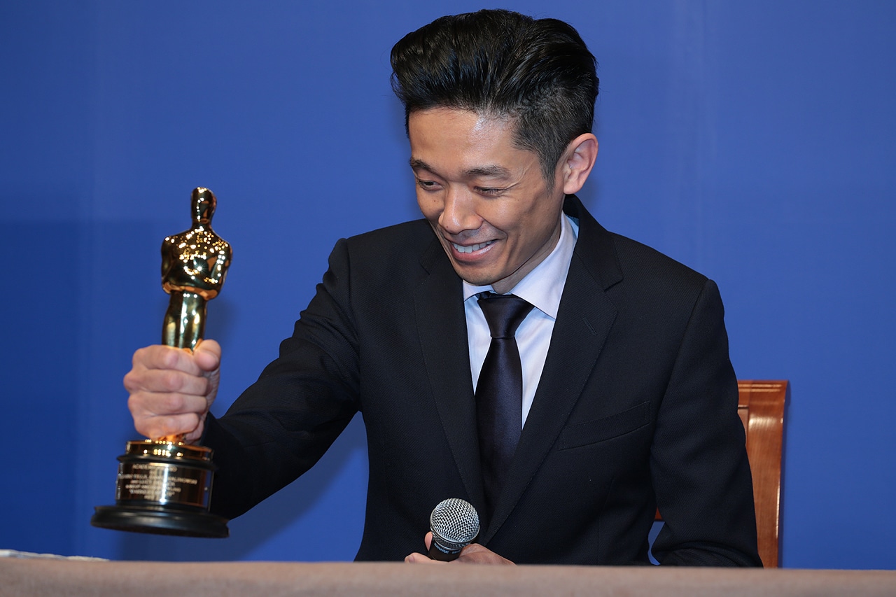 オスカー像をテーブルに置く辻一弘。