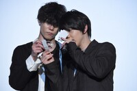 当選番号が書かれた半券を見る輝山立（右）と、ルーペをかざして手助けをする玉城裕規（左）。