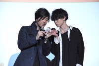 当選番号を確認する中村誠治郎（左）と玉城裕規（右）。