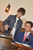 習ったばかりのワインの注ぎ方を実践する岩田剛典（左）。