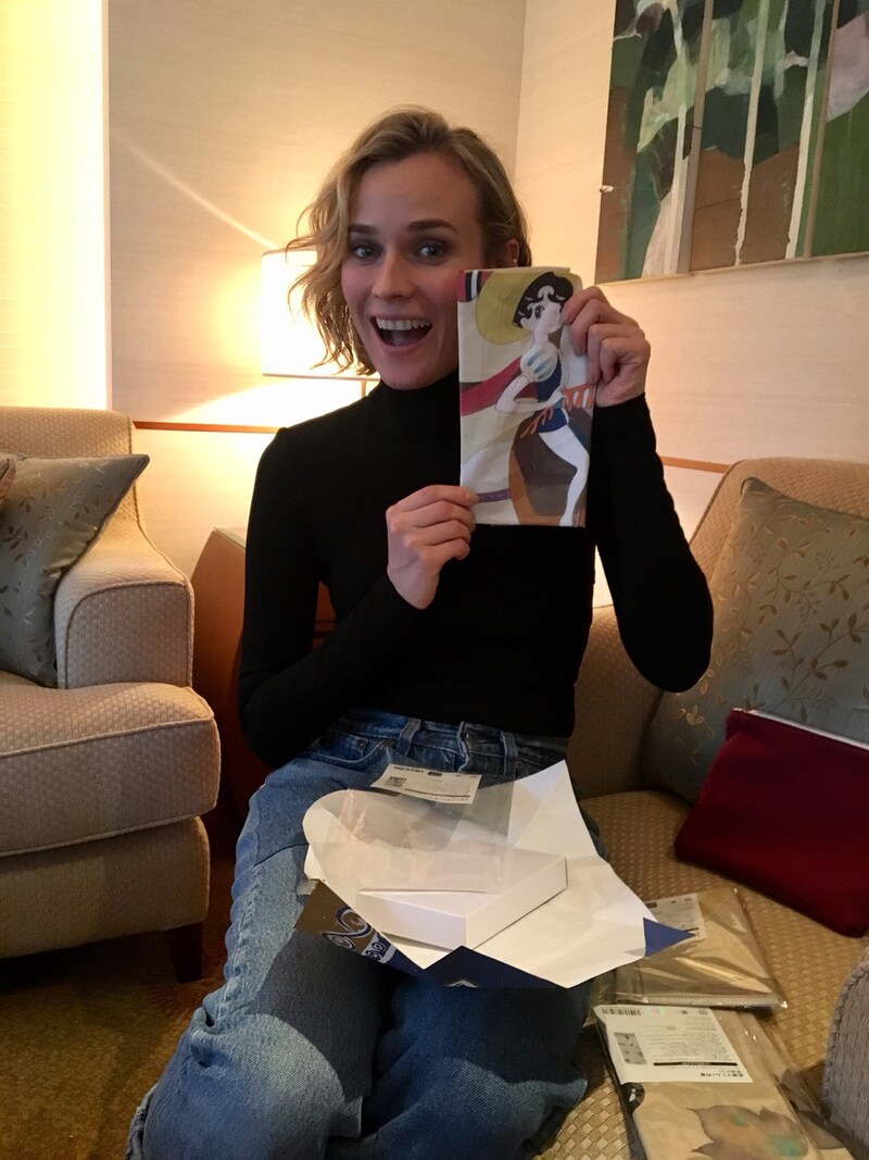 「リボンの騎士」の絵柄が入った手ぬぐいをプレゼントされ喜ぶダイアン・クルーガー。