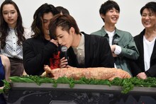 豚の丸焼きをまじまじと見る藤田富（中央）。