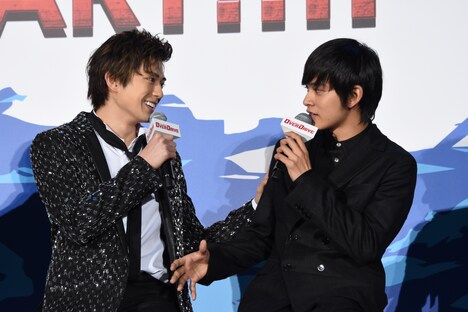 北村匠海（右）の腕を触る新田真剣佑（左）。