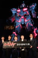 ライトアップされた実物大ユニコーンガンダム立像と登壇者。