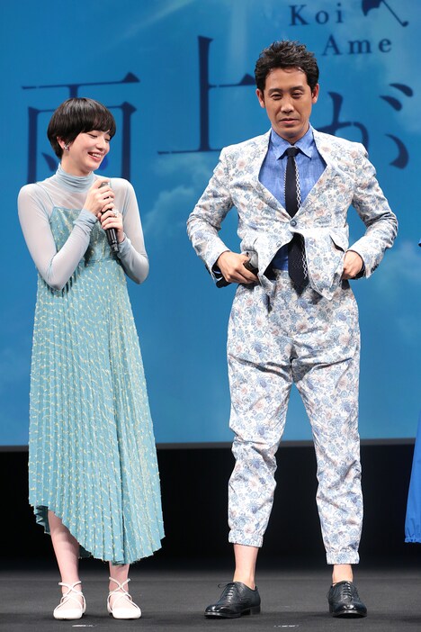 小松菜奈(左)と、脚の長さを強調するためにパンツの裾を上げる大泉洋(右)。