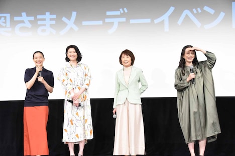 女性客が掲げるボードを見るキャストたち。