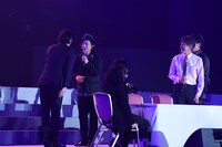 ステージ上で挨拶する姜暢雄（左）と高橋悠也（左から2番目）。