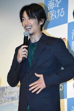 服を着ていることをアピールするディーン・フジオカ。