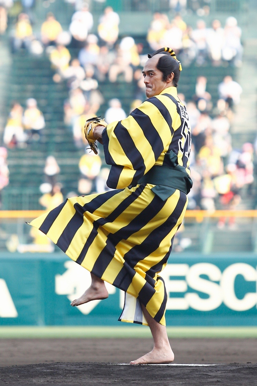 投球フォームに入る阿部寛。