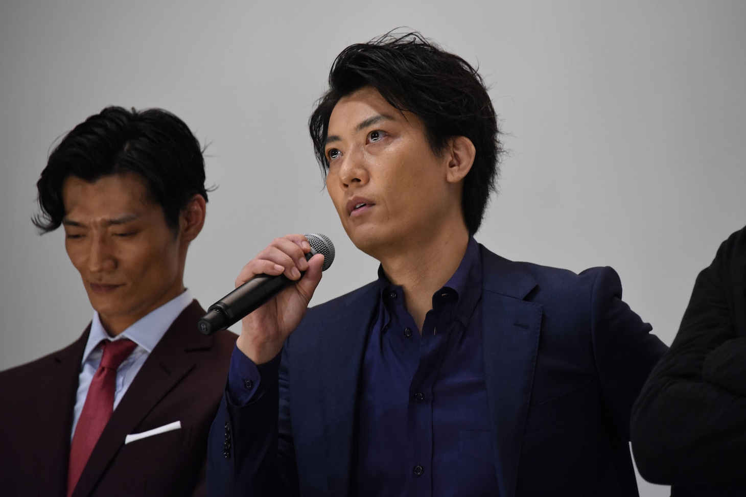 目に涙を溜める俊藤光利（右）。