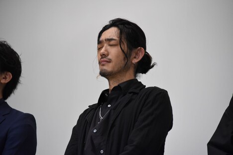 ぐっとまぶたを閉じる谷口賢志。