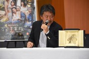 パルムドールのトロフィーを見る是枝裕和。