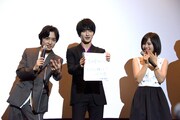 松岡広大(左)にうながされ、取材カメラに色紙をアピールする横浜流星(中央)。