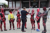 コスプレイヤーたちとハイタッチを交わすライアン・レイノルズ。