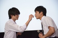 佐藤寛太（右）にケーキを食べさせる金子大地（左）。