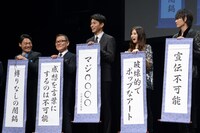 掛け軸を見せる登壇者たち。