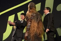 チューバッカと写真を撮るミキ亜生（左）と、自分も映ろうとしてジャンプする昴生（右）。