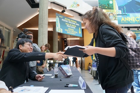 現地のファンと交流する細田守（左）。